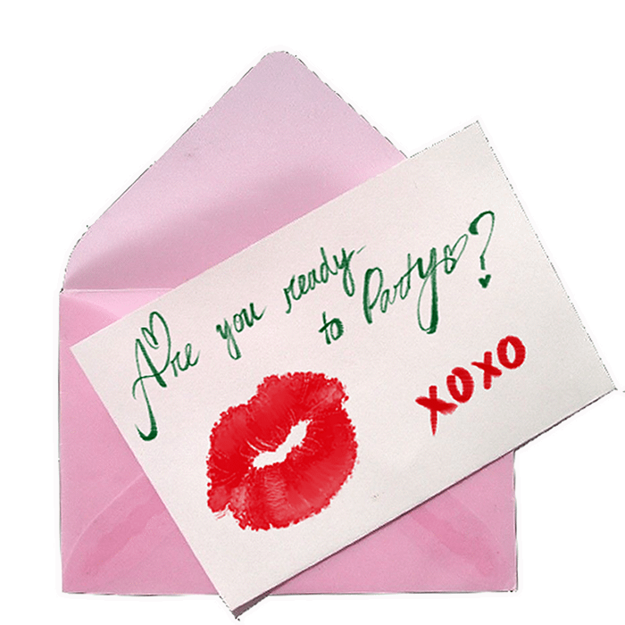 A light pink open envelope is placed over a teal and pink polka-dot wallpaper. The letter says, "Are you ready to party? xoxo" with a lipstick kiss mark.